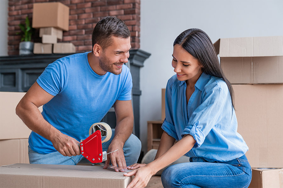 Couple taping up a packing box for moving